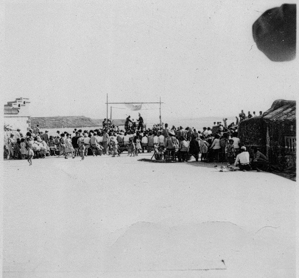 義士碼頭尚未築港前的大池村南方海灣，拍攝時村內正在舉行酬神子弟戲。當時無人能預料，此處會出現一座只有四十年壽命的義士碼頭。